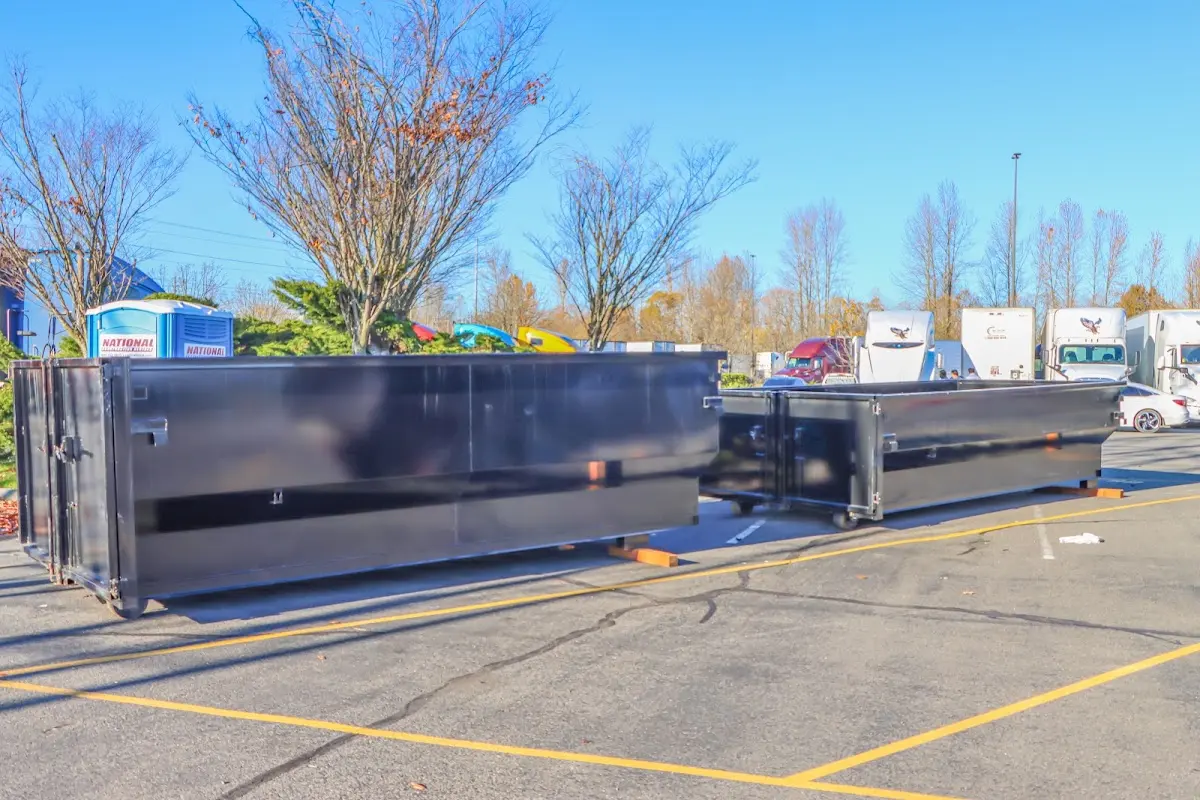 Professional dumpster rental service with roll-off container on residential driveway in Heeia
